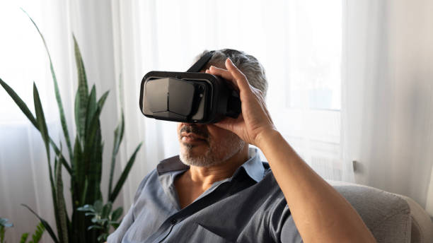 istock Senior man experiences VR glasses excitement at home 2165732738