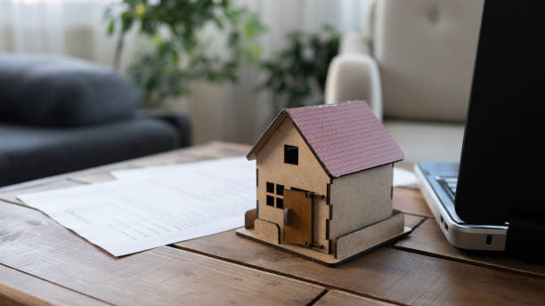 istock Laptop and house model on the table at home 2165732817