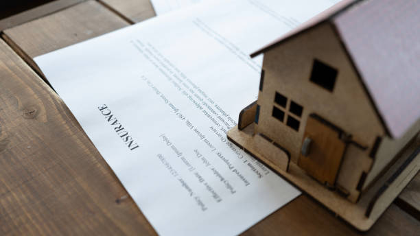 istock Home insurance contract and model house on table 2165732836
