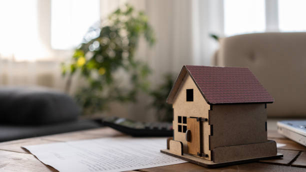 istock Laptop and house model on the table at home 2165732838