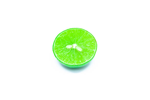 Close-up of a fresh green lime, with one whole and sliced pieces, isolated on a white background.