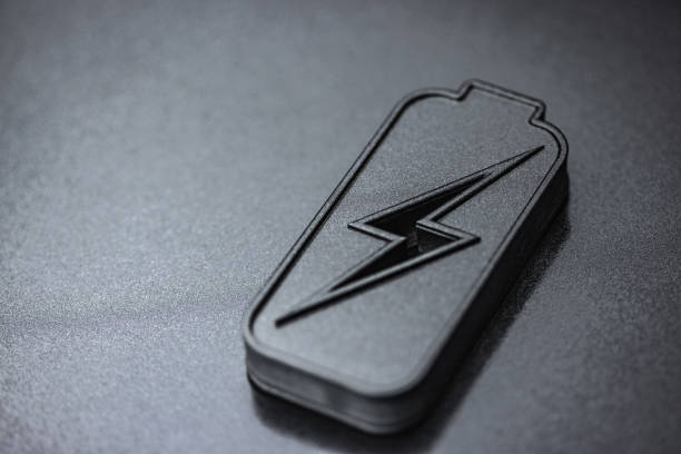 Energy concept. Battery energy technology background. Charged battery icon representing innovative power technologies and sustainability on dark background. Minimalistic setup with copy space. Elements painted with dark graphite metallic paint