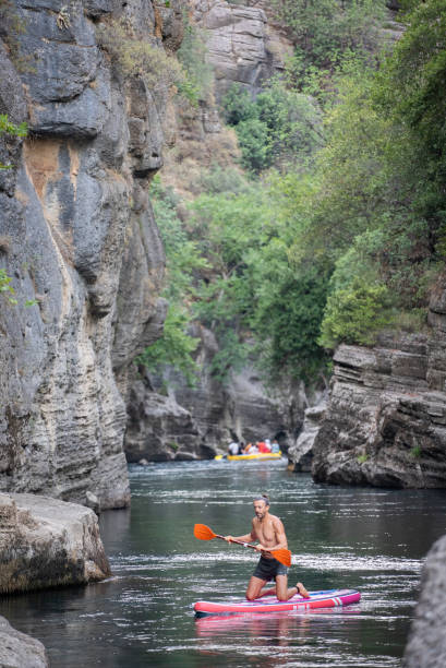 istock Mature men floating on SUP in Canyon 2165738600