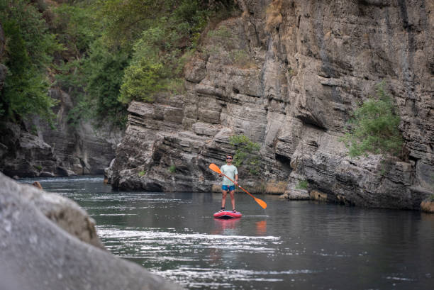 istock Man rowing across narrow cliffs in canyon 2165739873