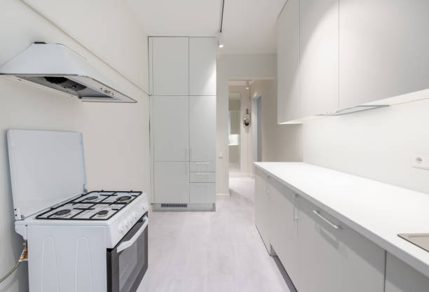 istock Scandinavian Style Cozy Modern Open Bright Minimalism Kitchen Home Interior. Oven, Faucet, and Furniture in Background. White Cabinets, LED Lights 2165741312