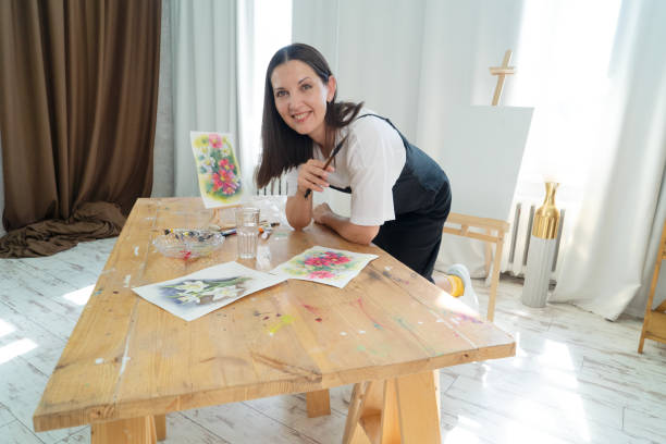 istock A Creative Artist is diligently at work in a bright and vibrant studio surrounded by stunning floral paintings 2165741844