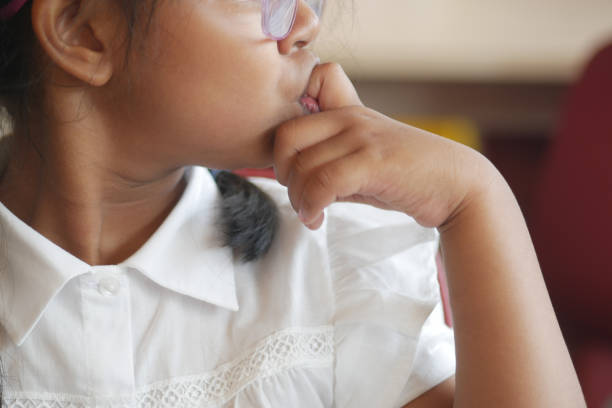 child girl biting her nails at home