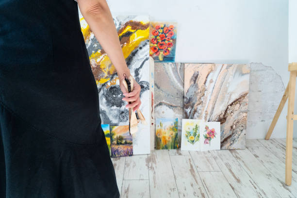 istock A Creative Artist is diligently at work in a bright and vibrant studio surrounded by stunning floral paintings 2165741964