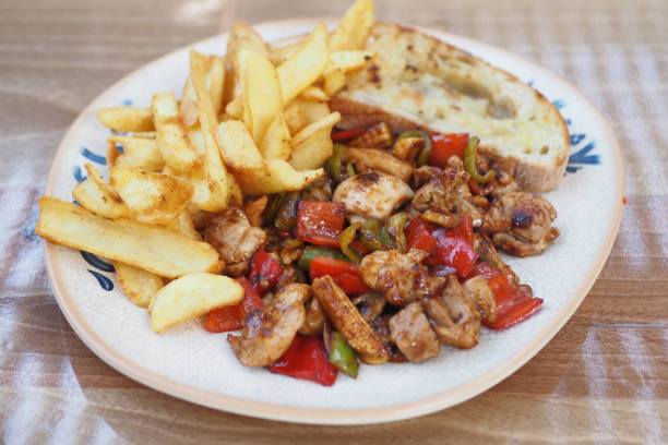 istock A plate filled with Delicious Chicken StirFry accompanied by Chips and Garlic Bread 2165743839