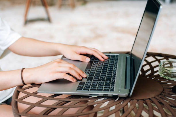 istock Woman's hands working on laptop in summer cafe 2165746202