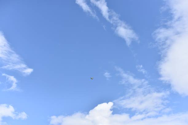 istock Small plane in the blue sky with clouds 2165747511