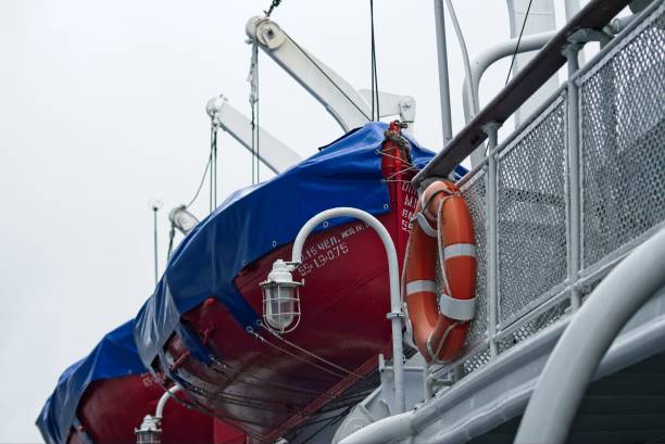 Old Ladoga, Russia, July 8, 2024.View of the upper deck of a large tourist ship with sheathed lifeboats installed on it, painted in bright colors, an iron fence, a lifebuoy, special equipment, ship equipment, river transport.