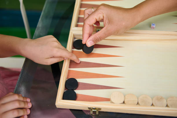 istock Hands playing a backgammon game on a wooden board 2165764027