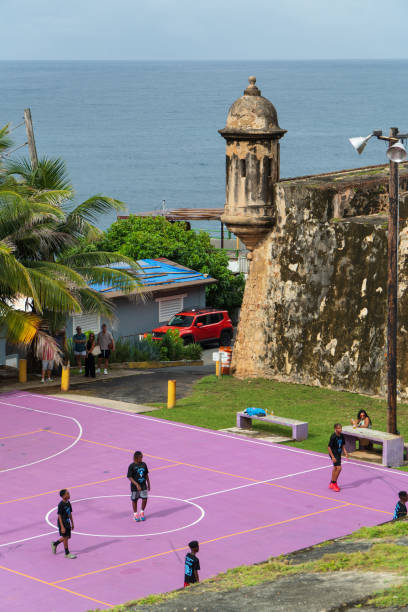 El Morro in old San Juan  Puerto Rico, August 2nd 2024, children play basketball in front of one of many historic protective turrets that abound in the city of old San Juan one of Puerto Rico's world class tourist destinations.