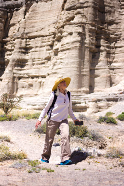 istock Abiquiu, NM: Senior Woman Hiking Near Sandstone Cliffs 2165773634