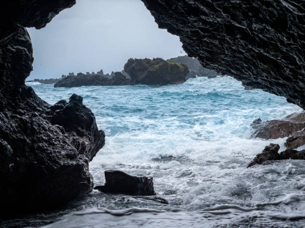 istock Looking at the blue ocean out of a cave 2165774266