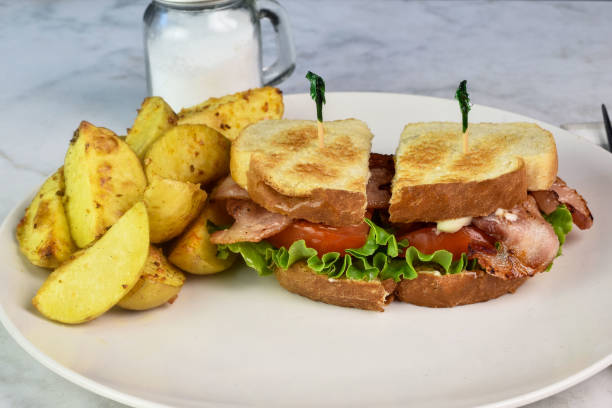 istock bacon , lettuce ,and tomato sandwich with potato wedges 2165775173