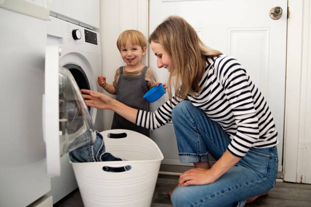 istock Young mother and toddler son doing laundry at home. 2165776210