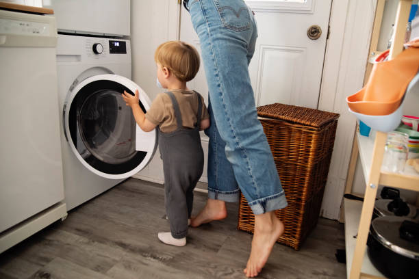 istock Young mother and toddler son doing laundry at home. 2165776239