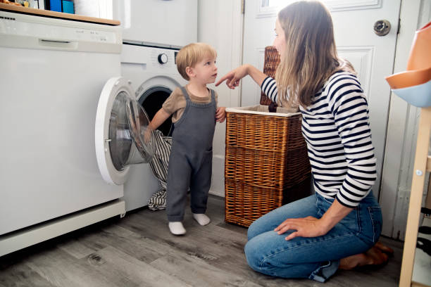 istock Young mother and toddler son doing laundry at home. 2165776253