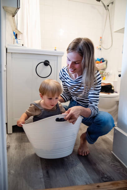 istock Young mother and toddler son doing laundry at home. 2165776260