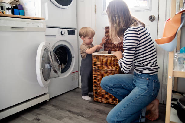 istock Young mother and toddler son doing laundry at home. 2165776276