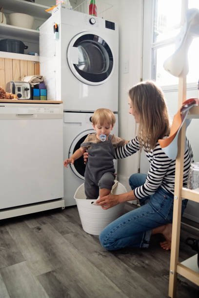 istock Young mother and toddler son doing laundry at home. 2165776311