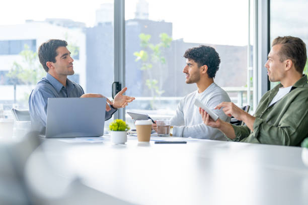 istock Three business men meeting and sharing ideas in the board room. They are using computers and digital tablets 2165776317