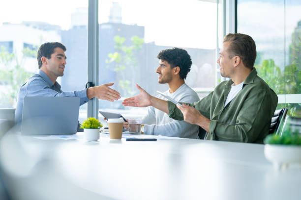 istock Three business men meeting with a handshake in the board room. 2165776491