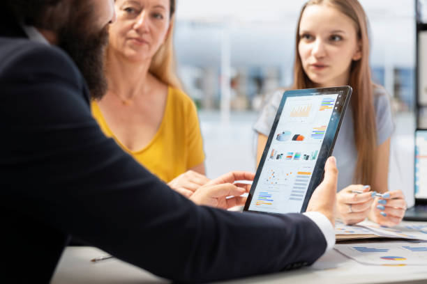 istock Agent helps family set realistic financial goals, showing them statistics 2165776513