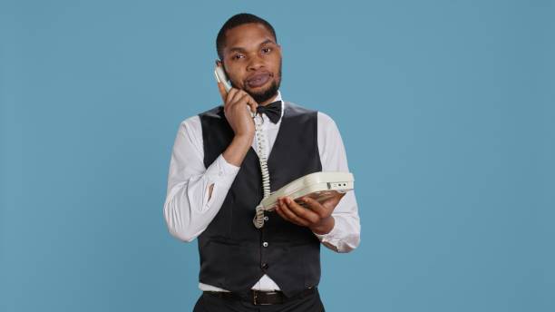 istock Bellboy concierge staff answering landline phone call to make reservations 2165777083