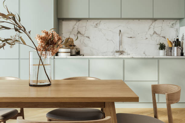 Close up of dinning table in kitchen interior, cabinet with modern kitchenware and sink with stove. Minimalist cooking area with wooden design