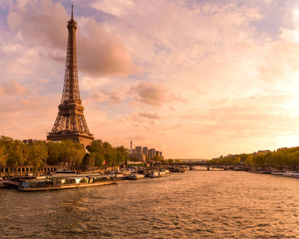 istock Sunset Seine - A panoramic sunset view of River Seine, with the iconic Eiffel Tower standing tall at shore and against colorful sky, on a lovely Spring evening. Paris, France. 2165782478