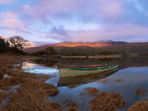 istock Serene Dawn over a Tranquil Lake with Rowboat 2165783230