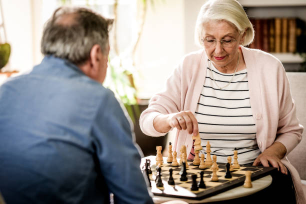 istock Elderly Couple Engaged in Chess Game at Home 2165789482