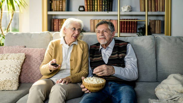 istock Elderly Couple Enjoying Television Time with Popcorn 2165789520