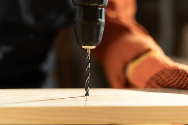 istock Power electric screwdriver, close-up. Female carpenter working with a hand tool in workshop. 2165794799