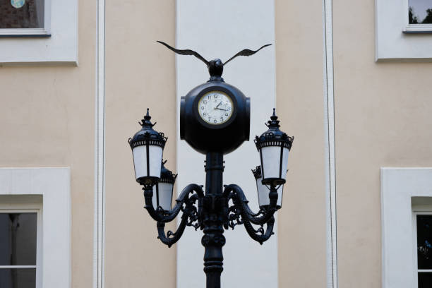 Vilnius, Lithuania. June 28, 2024. Old street lamp with a clock and a bird (probably an eagle)