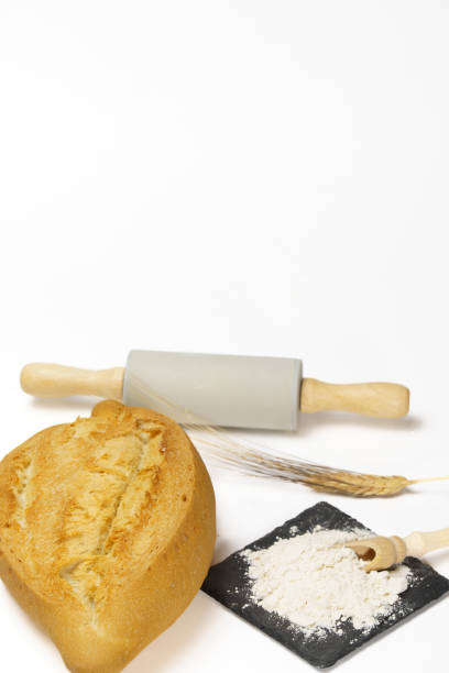 soft bread with flour, ears of wheat and a rolling pin isolated on a white background and copy space