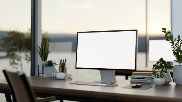 istock A computer desk in a modern office surrounded by large windows with a lake view, a computer mockup 2165799735