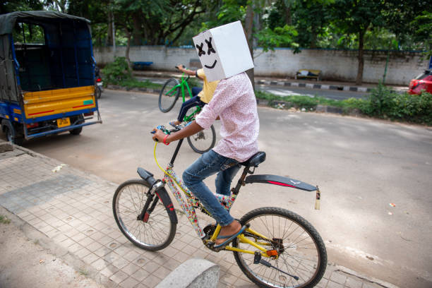 Bengaluru, Karnataka, India- Sep 20, 2021:  Child riding bicycle with a box on his head.