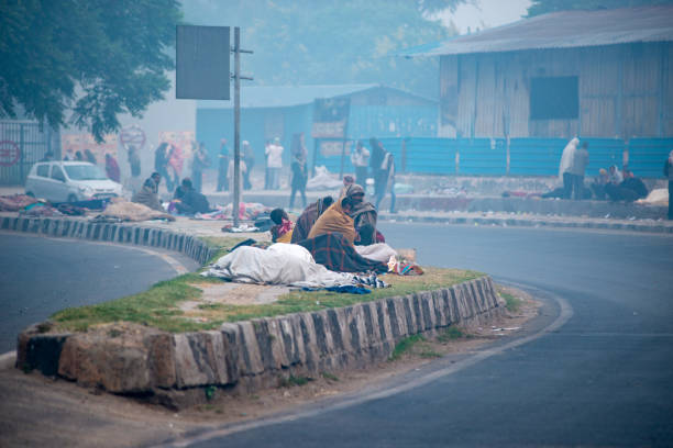 New Delhi, India-Nov 9. 2021: Early morning shot of homeless people sleeping along the road near Kashmiri Gate, spending the night on a road divider.