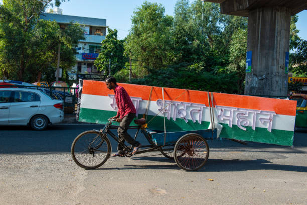 New Delhi, India-Oct 2 2022: A man carrying a tricolor board on a tricycle rickshaw, with the tricolor text 'Mera Bharat Mahan' written in Hindi, meaning 'My India is Great.