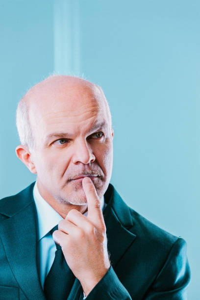 Mature businessman in a suit, thinking deeply in his office, showing wisdom and determination as he strategizes a crucial decision