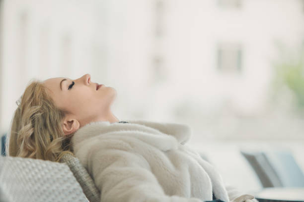 istock Young woman relaxing on sofa at home 2165807419
