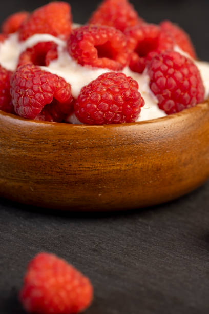 fresh yogurt with raspberry flavor and whole red raspberries, raspberry yogurt on the table