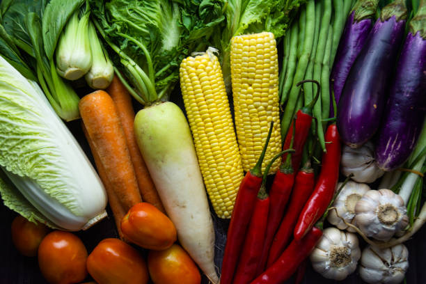 istock Fresh Mixed Raw Vegetables on Wooden Table – Corn, Tomatoes, Garlic, Lettuce, and More 2165810562