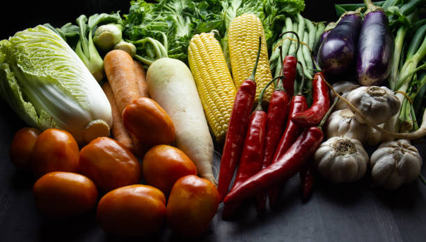 istock Fresh Mixed Raw Vegetables on Wooden Table – Corn, Tomatoes, Garlic, Lettuce, and More 2165810563