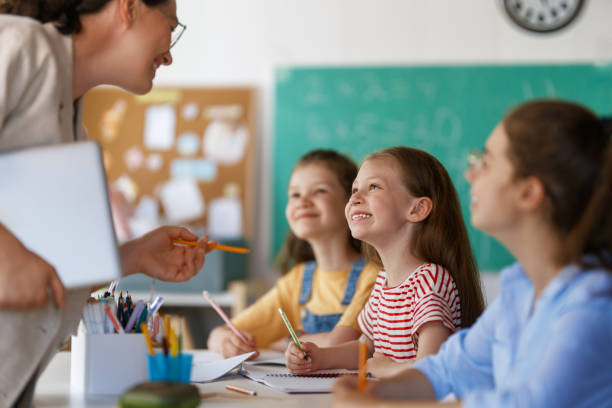 istock Happy kids and teacher at school 2165815715
