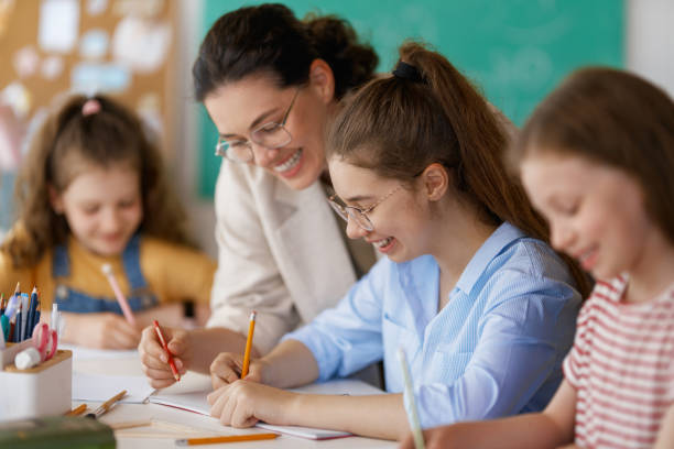istock Happy kids and teacher at school 2165815738